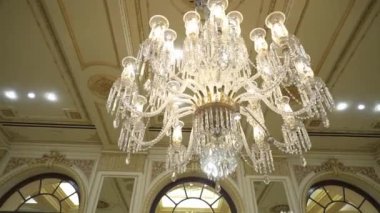 Göz kamaştırıcı bir kristal avizenin yakından görüntüsü. Karmaşık detaylarıyla zarif bir iç mekanı aydınlatıyor. Varlıklı tasarım sonsuz bir lüks sergiliyor..