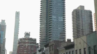 New York City, New York, ABD - 08.01.2024: Şehir manzarasına karşı yükselen gökdelenler. Cam binalar ve geleneksel yapıların karışımı modern bir şehri vurguluyor.