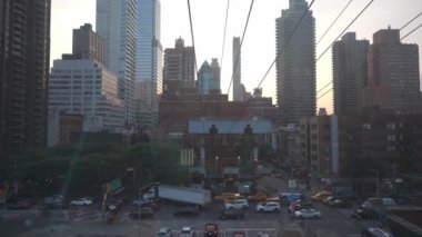 New York City, New York, ABD - 08.01.2024: Yükselen gökdelenler ve tramvay kabloları ile Manhattan City caddesini alacakaranlıkta hareketlendirmek. Arabalar, taksiler ve yayalar yoğun kentlerde yol alırlar.