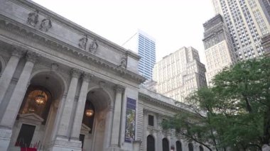 New York City, New York, ABD - 07.29.2024: New York 'taki tarihi bir kütüphanenin çarpıcı mimarisinde bir yürüyüş. Bina, gökdelenler ve gökdelenler arasında karmaşık tasarımlar sergiliyor.