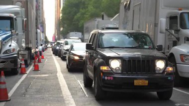 New York, New York, New York, ABD - 07.29.2024: Günbatımında kalabalık bir şehir caddesinde arabalar tampon tampona gidiyor. Trafiğe yakalanan banliyö sakinleri, kamyonlar ve araçlar sıkışık bir şeride dizildi..