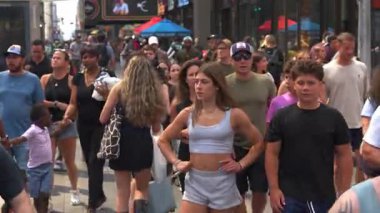New York City, New York, ABD - 07.29.2024: Manhattan 'da güneşli bir yaz gününde çeşitli kalabalıklar kalabalık caddelerde dolaşırken canlı bir sahne gözler önüne seriliyor. İnsanlar sohbete dalıp eğleniyorlar.