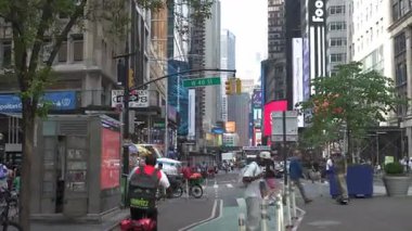 New York, New York, New York, ABD - 07.29.2024: Meşgul Manhattan sokakları Times Meydanı yakınlarındaki kentsel sahnelerden bisikletçilerin dokumasıyla canlandı. Canlı şehir atmosferi New York yaşamının özünü yakalıyor.