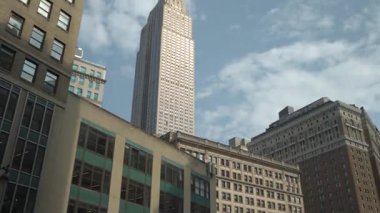 Gökyüzünün açık mavi arkaplanının karşısında yükselen Empire State Binası 'nın görüntüsünün keyfini çıkarın. Binalar dik durdukça şehrin hareketli enerjisi hissedilir..