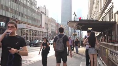New York City, New York, ABD - 07.29.2024: Yayalar caddelerde yürürken Manhattan 'ın canlı atmosferi canlanıyor ve kentler canlı enerji gösteriyor. Modern binaların karışımı ve