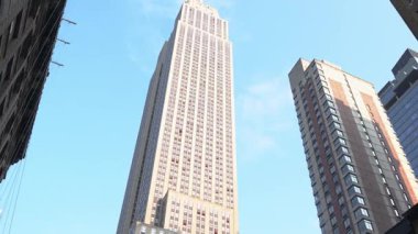 New York City, New York, ABD - 07.29.2024: Empire State Binası 'nın göz kamaştırıcı mimarisinin parlak mavi gökyüzüne ulaşmasına tanık olun. Manhattan 'ın canlı atmosferini keşfedin.