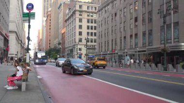 New York City, New York, ABD - 07.29.2024: Manhattan sokakları etkinliklerle doludur. Yayalar canlı şehir atmosferinin tadını çıkarırken otobüsler ve taksiler yolda ilerliyorlar. Sıcak bir gün batımı