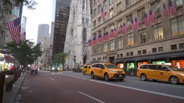 New York City, New York, ABD - 07.29.2024: Parlak sarı taksilerin Amerikan bayraklarıyla süslenmiş tarihi binaların önünden geçtiği Manhattan 'ın canlı caddelerinde gezinin. Şehrin cazibesi parlıyor