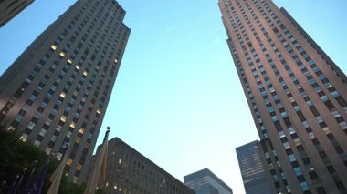 New York City, New York, ABD - 07.29.2024: Akşam ışıkları ikonik Art Deco gökdelenini aydınlatırken New York 'taki Rockefeller Center' ın yükselen manzarası. Çevredeki binalar...
