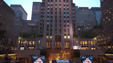 New York City, New York, ABD - 07.29.2024: Manhattan 'daki Rockefeller Center' ı gün batımında keşfedin, canlı ışıklar, hareketli kalabalıklar ve ikonik binaların mimari tasarımı.