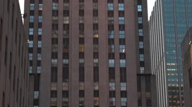 Uzun binalar, akşam alacakaranlığı onların özelliklerini artırırken Manhattan 'da eşsiz mimari tasarımlar ve zıt dokular sergiliyor. Işıklar parlamaya başlıyor, canlı bir şehir atmosferi yaratıyor..