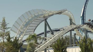 Orlando, Florida, ABD - 11.15.2024: Florida 'da bulunan Sea World' de hız treninin heyecanını yaşayın. Güneşli bir günde verimli yeşilliklerle çevrili heyecanlı dönüşlerin ve damlaların tadını çıkar. Herkes için bir macera bekliyor..