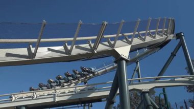 Heyecan peşinde koşanlar heyecan içinde çığlık atıyorlar. Hız treni gibi dönüyorlar ve yukarıdaki açık mavi gökyüzüne doğru dönüyorlar. Eğlence ve macera dolu bir deniz tema parkında..