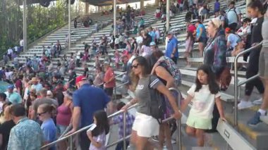 Orlando, Florida, ABD - 11.15.2024: Aileler heyecan verici bir performansa hazırlanırken deniz parkında vakit geçiriyorlar. Titreşimli atmosfer beklenti ve gevezelikle dolu..