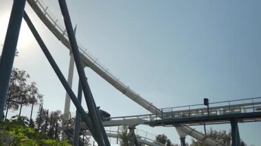 Deniz macerası parkında keyifli bir günün tadını çıkarın. Ziyaretçiler, yemyeşil ve heyecan verici manzaralarla çevrili açık mavi gökyüzünün altında heyecan verici bir su kaydırağına hazırlanıyor..