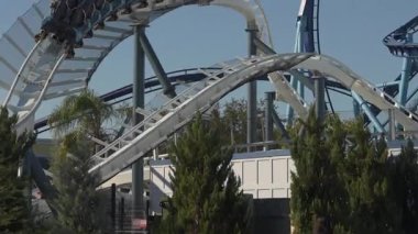 Heyecan verici lunapark trenleri yemyeşil ve hareketli sürüş arasında dönüp duruyor. Ziyaretçiler, açık mavi gökyüzünün altındaki deniz temalı lunaparkın macera ve heyecanının tadını çıkarıyorlar..