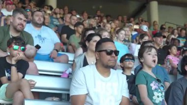 Orlando, Florida, ABD - 11.15.2024: Aileler, Deniz Dünyası 'nda heyecan verici bir performans sergilemek için tribünlerde toplandılar. Güneşli bir günde, çocuklar neşeli bir atmosfer yaratıp, neşe içinde gülüyorlar..