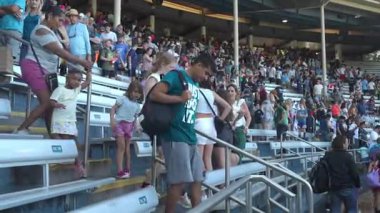 Orlando, Florida, ABD - 11.15.2024: İnsanlar bir etkinlikten sonra merdivenlerden inip stadyumu terk ediyorlar. Sahne çeşitli bir kalabalığı hareket halinde yakalıyor, bazıları gülümsüyor, sohbet ediyor veya telefonları kontrol ediyor..