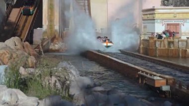 Orlando, Florida, ABD - 11.15.2024: Ziyaretçiler dik iniş ve sıçramalarla dolu bir deniz parkında heyecanlı bir su yolculuğunun keyfini çıkarıyorlar. Biniciler yolculuk boyunca heyecan verici anlar yaşarken kahkahalar ve çığlıklar havayı dolduruyor..