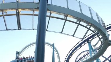 Orlando, Florida, ABD - 11.15.2024: Sürücüler hız treninde keskin virajlarda süzülürken yükseklerde süzülmenin heyecanını yaşayın. Deniz Dünyası eğlence parkındaki çarpıcı manzaranın ve heyecan verici hızların tadını çıkarın..