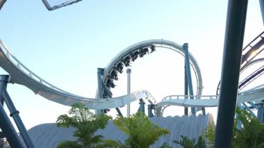 Sürücüler heyecan verici lunapark treninde dönerken sevinçle çığlık atıyorlar. Açık hava, Deniz Dünyası 'ndaki eğlence parkı deneyiminin neşesini arttırıyor..