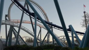 Lunaparkta alacakaranlıkta hız trenlerinin ve heyecanlı sürüşlerin tadını çıkarın. Macera arayanların neşe ve adrenalini yakalaması için mükemmel bir zaman..