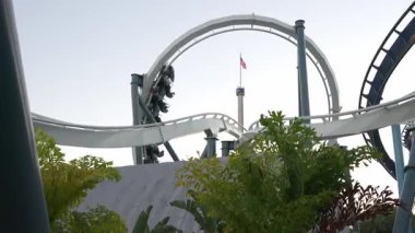 Orlando, Florida, ABD - 11.15.2024: Güneş batarken Deniz Dünyası eğlence parkında heyecanlı sürüşlerin heyecanını yaşayın. Atmosfer kahkahalarla, çığlıklarla ve günlerinin tadını çıkaran ziyaretçilerin neşeli ifadeleriyle dolu..