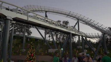 Orlando, Florida, ABD - 11.15.2024: Deniz Dünyası 'nda heyecan verici anlar yaşanıyor konuklar Noel süsleriyle çevrili lunapark treni yolculuğunun keyfini çıkarırken. Eğlence ve kahkaha bu unutulmaz gecede havayı dolduruyor..