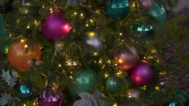 Güzel Noel ağacı parlak süsler ve parlayan ışıklarla kaplıdır. Alacakaranlıkta arka planda bir sokak lambası parlıyor.