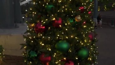 Renkli süsler eğlence parkındaki güzel ışıklandırılmış bir Noel ağacını süslüyor ve neşeli bir atmosfer yaratıyor. Ziyaretçiler, gece çöktüğünde gösterinin keyfini çıkararak mevsimlik ruhlarını güçlendirirler..