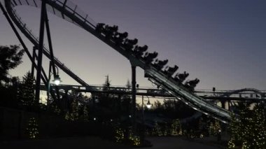 Gece çöktüğünde bir hız treni raylara tırmanıyor. Aşağıdaki yolda parıldayan ışıkları olan Noel ağaçları.