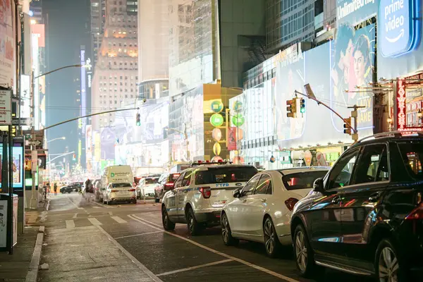 New York City, New York, ABD - 07.28.2024: Manhattan 'ın göbeğinde, hareketli caddeler geceleri araçlar ve ışıklı reklam panoları ile doludur. Canlı atmosfer, New York şehrinin enerjisini ve ikonik ufuk çizgisini gösteriyor..
