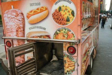 New York, New York, New York, ABD - 07.29.2024: New York 'ta renkli bir helal gıda sepetinin detaylı bir yakın çekimi, menüde sosisli, fasulyeli pilav ve balıklı pilav gibi öğelerin fotoğraflarını sergiliyor. Yan panelde sokak yiyecekleri kültürü cesur bir şekilde vurgulanıyor