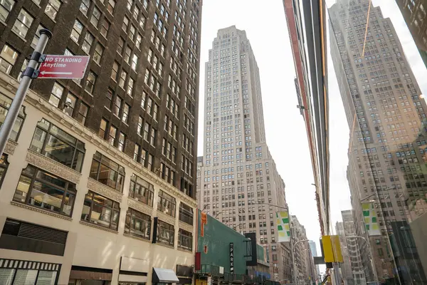 Manhattan 'ın göbeğinde dar bir caddede uzun binalar var. Bir cephe yansıtır aynadaki ufuk çizgisini.
