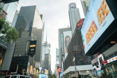New York City, New York, ABD - 07.29.2024: Times Square, New York 'ta reklam panoları, marka reklamları ve cam kuleler sahneyi dolduruyor. Gıda ve içecek reklamları gün ışığında bölgeyi aydınlatıyor..