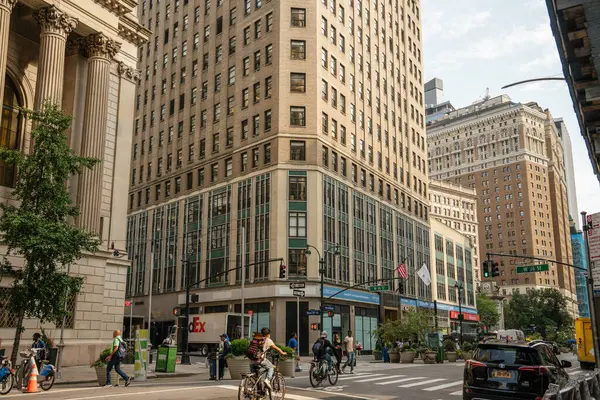 New York City, New York, ABD - 07.29.2024: İnsanlar Midtown 'da bir caddede yürür ve bisiklete biner. Binalar, mağazalar ve kargo kamyonu hareketli şehir sahnesine enerji katıyor..
