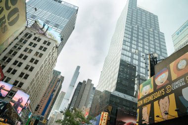New York City, New York, ABD - 07.29.2024: Manhattan şehir merkezindeki parlayan reklam panolarının arkasında cam gökdelenler yükseliyor. Modern reklam ve binaların canlı karışımı şehir enerjisini yansıtır..