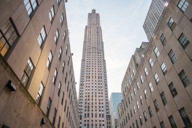 Yükselen Rockefeller Merkezi Manhattan şehir merkezindeki simetrik Art Deco binaları arasında yükselir. İkonik gökdelen, tarihi taş cepheleriyle çerçevelenmiş yumuşak, akşam gökyüzünün altında dimdik ayakta duruyor..