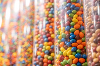 Dikey ekran tüplerinde çikolatalı şekerlemelerin yakın çekimi. Çeşitli ziyafetlerden oluşan neşeli ve neşeli bir düzenleme.