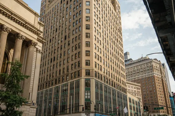 Modern cam pencereli büyük bir tuğla bina işlek bir köşede neoklasik mimariyle karşılaşıyor. Sahne Manhattan 'daki tarihsel ve çağdaş tarzların bir karşıtlığını gösteriyor.