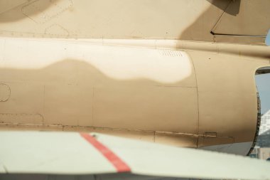 Kamuflaj boyalı askeri uçağın arka kısmının detaylı bir görüntüsü. Görüntü, uçak gövdesi boyunca panel çizgileri, perçinler ve yumuşak gölgeleri vurgular.