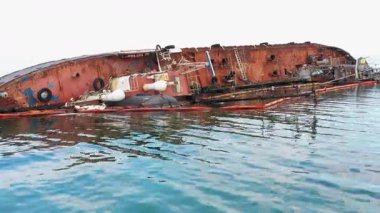 Broken rusty oil tanker ship in the shallow water. Sunken drowned ship after the crash.