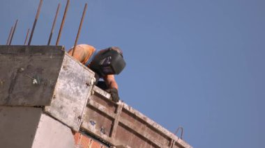 Yuzhne, Ukrayna - 08.09.2020: İnşaat alanında kaynak yapan ve maskesini çıkaran adam. Arka planda mavi gökyüzü.