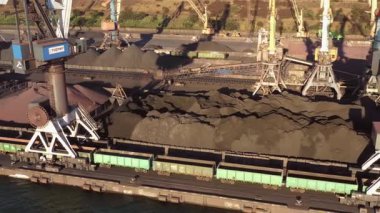 Odesa, Ukrayna - 12.07.2021: Bir deniz limanında sanayi vinçleri ve kömür yığınları. Nakliye ve ulaşım.