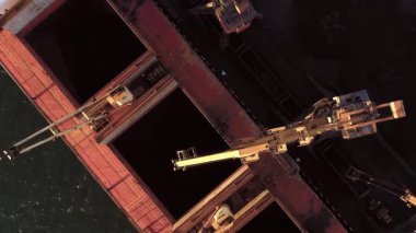 Endüstriyel vinçler tanker gemisine kömür taşıyor. Nakliye ve ulaşım kavramı.