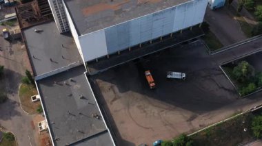 Depo yakınlarındaki sanayi bölgesinde iki çöp kamyonu. Havadan üst görünüm.