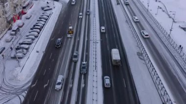 Kış kenti caddesinde arabaların üzerinden hava manzarası. Arka planda şehrin ufuk çizgisi.