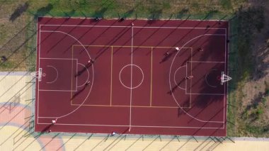 Erkek çocukların kırmızı sahada basketbol oynamalarının en iyi görüntüsü. Hızlı hız hareketi.