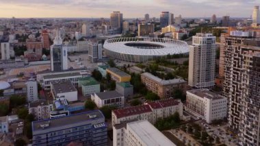 Ukrayna Kiev 'deki gökdelenlerin ve modern şehir binalarının havadan panoramik manzarası. Şehir manzarası ve futbol stadyumu. İnsansız hava aracından görüntüle.