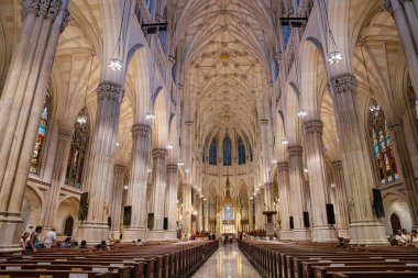 New York City, New York, ABD - 07.31.2024: Manhattan 'daki St. Patricks Katedrali' nde turistler ve ibadet edenler görülüyor. Çekim büyük kemerleri, vitray pencereleri ve karmaşık Gotik mimariyi yakalar..